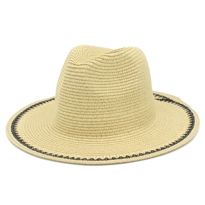 Detail of elegant straw hat with black geometric wave pattern on the brim and sun protection