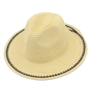 Close-up of elegant straw sun hat with black wavy woven stripe detail on edge