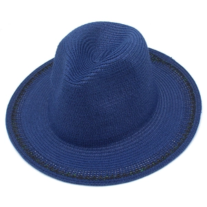 Close-up of deep blue woven sun hat with decorative wave pattern trim on brim