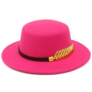 Detail of hot pink felt flat top fedora hat with black leather band and gold metal leaf
