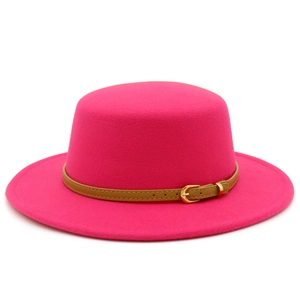Detail of fuchsia wool felt boater hat featuring a brown leather belt with gold buckle