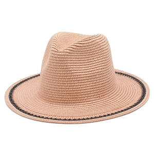 Close-up of peach woven straw fedora with black geometric embroidery on the wide brim