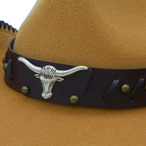 Detalle de sombrero vaquero con banda de cuero y adorno de cabeza de toro plateado