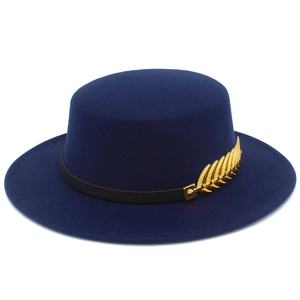 Detail of navy blue wool boater hat with black leather strap and gold feather pin