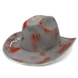 Close-up of gray felt cowboy hat with orange paint splatter and white ween text