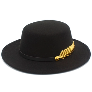 Detail of black fedora hat with premium leather band and golden metal leaf ornament