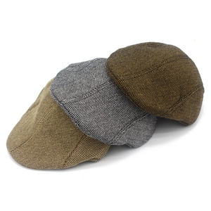 Detailopname van het visgraatpatroon en textuur op drie vintage newsboy caps