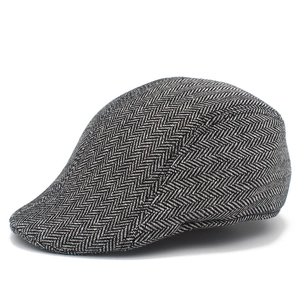 Detailopname van de klassieke zwart-witte visgraat tweed stof van deze stijlvolle platte pet