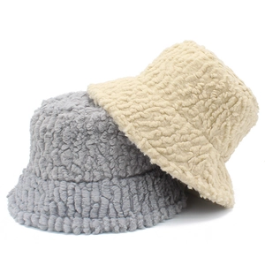 Detail of plush lamb wool bucket hats in grey and beige showing soft fuzzy texture