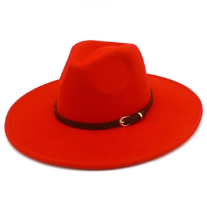 Detail of red wool fedora hat with wide brim, brown faux leather band and gold buckle