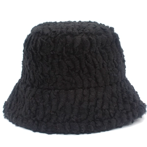 Macro detail of the thick black faux lamb wool texture on the winter bucket hat
