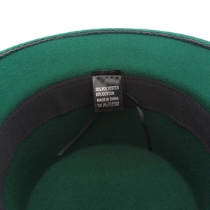Detail view of the green wool fedora interior featuring the care label and sweatband