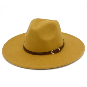 Detailed close-up of mustard yellow wool fedora hat with brown leather band and gold buckle