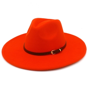 Detailed texture of bright orange wool fedora hat with brown leather belt and gold buckle