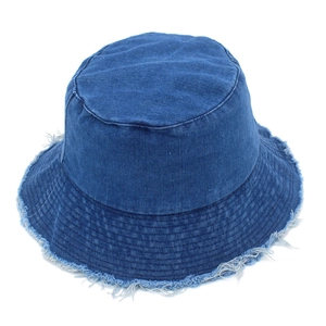 Détails des bords effilochés sur un chapeau bob en jean bleu foncé avec coton