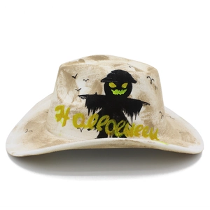Detail of distressed white cowboy hat with Halloween graphics and black bird silhouettes