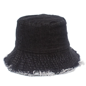 Détail d'un chapeau bob en coton noir avec bords effilochés et texture denim vintage