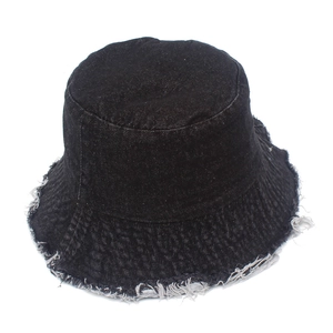 Gros plan sur un bob en coton noir avec bords effilochés et texture en denim délavé