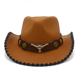 Detail of brown cowboy hat featuring bull head metal buckle and black braided edge