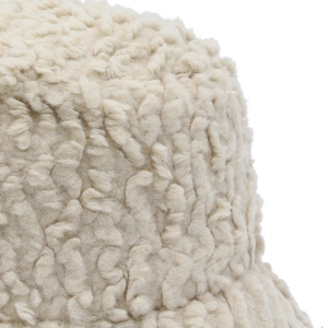 Close-up of the plush lamb wool fabric on a beige winter bucket hat showing soft texture