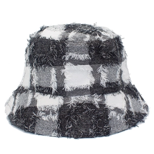 Dettaglio del cappello a secchiello a scacchi bianchi e neri con bordi sfilacciati e trama