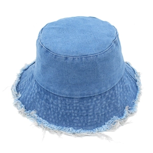 Détail d'un chapeau bob en jean avec bords effilochés et texture en coton bleu pur