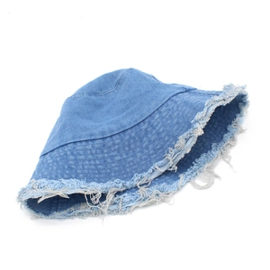 Détail d'un chapeau bob en denim bleu clair avec bords effilochés et texture vintage