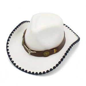 Close-up of white western cowboy hat with golden bull head metal emblem and leather band