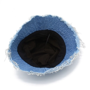 Détail des bords effilochés du bob en coton denim bleu clair avec doublure noire douce