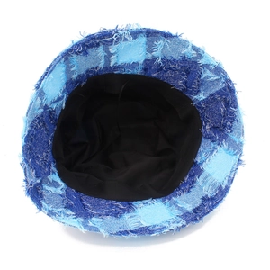 Dettaglio del cappello pescatore in denim patchwork blu con bordi sfrangiati e fodera