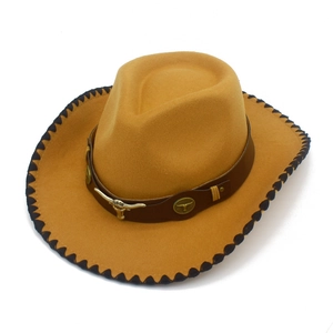 Detail of western cowboy hat with metal bull head emblem and braided brim edges
