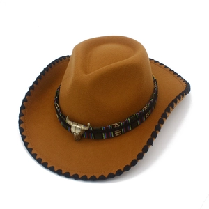 Detail of western brown felt hat featuring a silver bull head emblem and colorful band