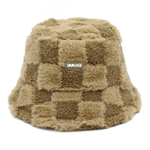 Detailed close-up of brown checkerboard plush bucket hat with IMMUNE rubber patch
