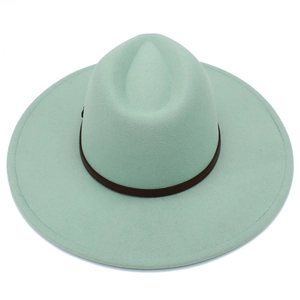 Detailed macro view of mint green wool fedora hat with brown leather belt trim decoration