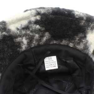 Detail of warm lamb wool bucket hat with black quilted lining and fabric care label