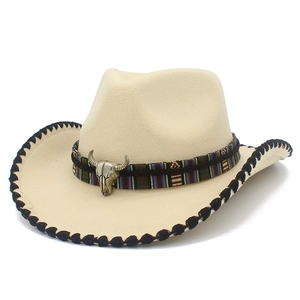 Detail of cream cowboy hat featuring ethnic colorful ribbon and metal bull head accessory