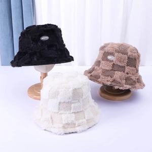 Detail view of stylish plush bucket hats in solid black and checkerboard patterns