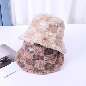 Detail of plush checkerboard bucket hats showing faux rabbit fur texture and brand label