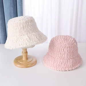 Detalle del sombrero de lana de cordero en beige y rosa mostrando su textura suave