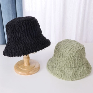 Primer plano de sombreros bucket de lana de cordero en negro y verde de textura gruesa