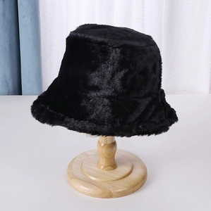 Close-up of black faux fur bucket hat material texture on a wooden stand