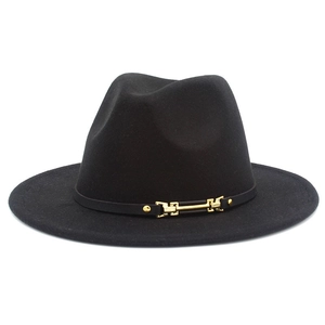 Detail of classic black wool fedora featuring a golden buckle and leather band trim
