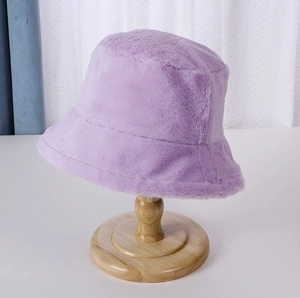 Classic purple plush bucket hat made of warm faux fur on a wooden display stand