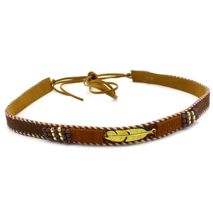 Detailed view of bohemian style ethnic hat band with golden metal feather and beads