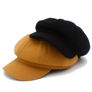 Gros plan de casquettes de gavroche en laine gingembre et noires avec texture épaisse