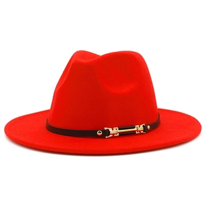 Close-up of red wool fedora featuring a black leather band with gold metal accents