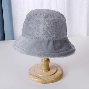 Close-up detail of soft gray plush bucket hat on wooden stand with fuzzy texture