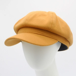 Texture détaillée du béret en laine jaune gingembre avec coutures fines et visière