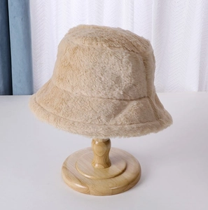 Detailed view of the thick plush bucket hat texture on a wooden display stand
