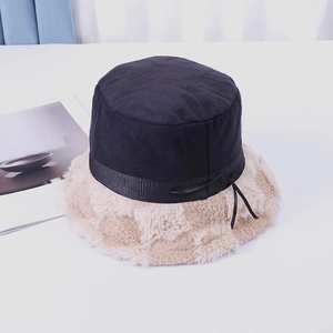 Detailed view of plush faux fur brim and ribbon bow on a stylish patchwork bucket hat